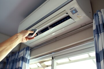 A male engineer is adjusting the remote control for the air conditioning system within a contemporary office environment, ensuring optimal comfort and efficiency for everyone in the workspace