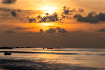 Obraz premium dramatic sunrise over quiet coastal shoreline at dawn