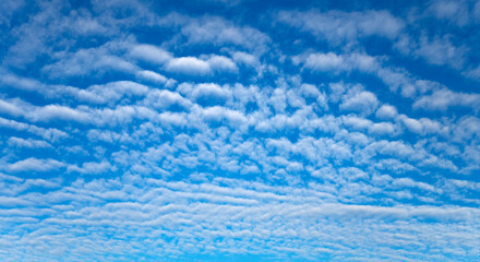 Cloud panorama in the blue sky above the North Sea coast on a sunny autumn day in Germany....