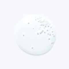 Close-up of white liquid with bubbles on light background highlighting texture and pattern.