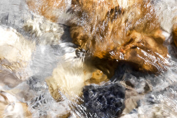 close-up water pattern with natural reflections in light earthy tones. abstract background with moving water surface. freshness, purity, and