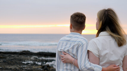A Couple Embracing at Sunset by the Serene Ocean, Surrounded by Natures Beauty and Tranquility