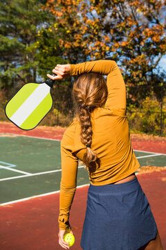 Woman playing pickleball in autumn