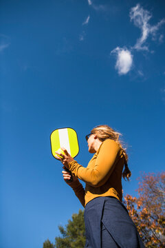 Woman playing pickleball in autumn