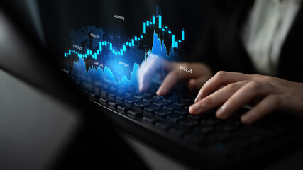 Close-up of a business professional hands on a laptop keyboard while analyzing financial charts and...