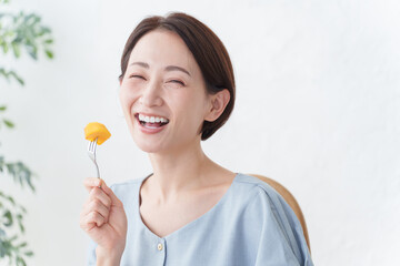 果物の柿を食べる女性