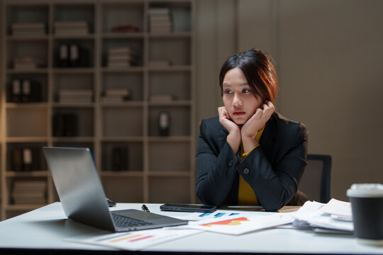Stressed businesswoman working late in dark office