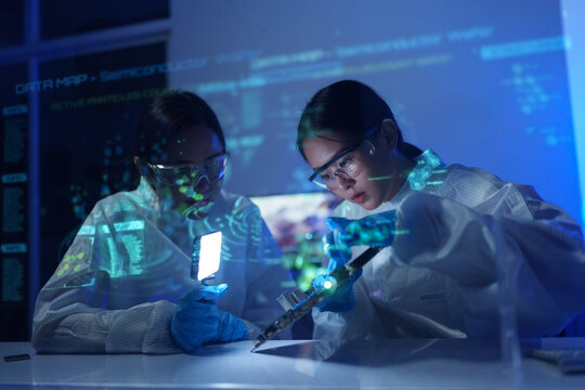 Engineers work in semiconductor or microchip labs in the electronics industry. Electronic engineers in computer technology, CPU maintenance, hardware, motherboard component upgrades.