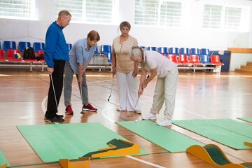 elderly group  plays mini golf for competitions in the sprot hall.  Kidult gaming in the gym....