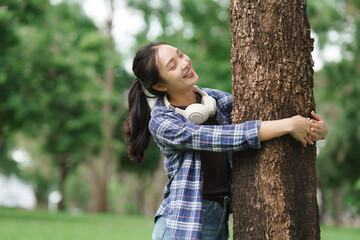 Young woman enjoying nature hugging live tree