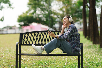 Young woman enjoying music outdoors via headphones