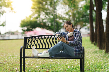 Young woman relaxing on bench using smartphone