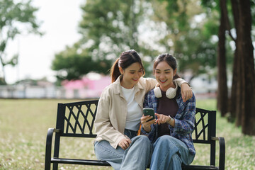 Young asian women sharing smartphone content in park