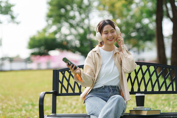 Young woman enjoying music listening to headphones outdoors