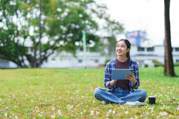 Asian student researching on tablet in park