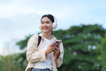 Young woman enjoying music outdoors using smartphone