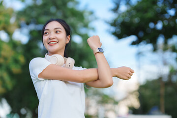 Young asian woman stretching arm starting outdoor workout