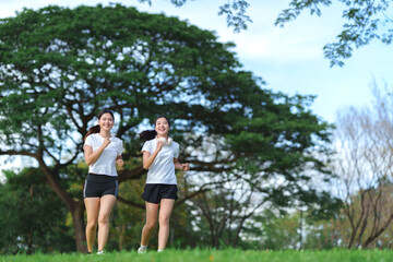 Happy young women jogging outdoors in park