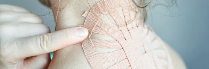 Caucasian female applying therapeutic tape on neck for pain relief and muscle support.