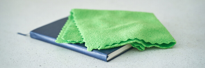 Closed blue notebook covered with green cloth on white surface - clean, organized, stationary,...