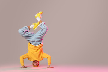 Handsome young man dancing hip-hop on grey background