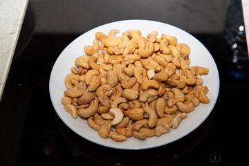 Cashews on a plate, top view. Loose cashews, close-up. Healthy eating concept.