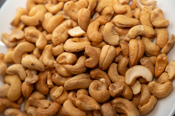Cashews on a plate, top view. Loose cashews, close-up. Healthy eating concept.