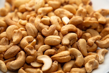 Cashews on a plate, top view. Loose cashews, close-up. Healthy eating concept.
