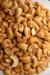 Cashews on a plate, top view. Loose cashews, close-up. Healthy eating concept.