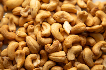 Cashews on a plate, top view. Loose cashews, close-up. Healthy eating concept.