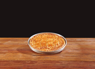 Delicious homemade savory pie with golden crispy layers, baked to perfection in a round tray. Perfect for family gatherings, traditional meals, or food photography showcasing authentic baked pastry.