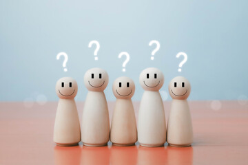 Wooden smiling figures with question marks above their heads on pastel background, representing curiosity, problem solving, learning, and creative thinking concepts.