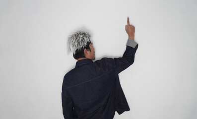 Rear view of a person with stylish bleached hair and dark denim jacket pointing a finger up and...