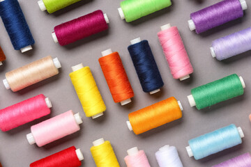 Many different thread spools on grey background