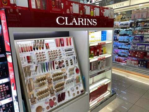Palma, Spain - October 16, 2025: Clarins cosmetics display in a retail store showcasing a variety of beauty products including lipsticks, foundations, and skincare items with bright lighting
