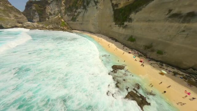 FPV drone flight over waves at a tropical beach in Bli.