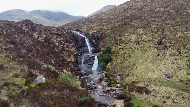 Drone footage capturing the scenic Eas a'Bhradain Waterfall cascading down the Scottish highlands