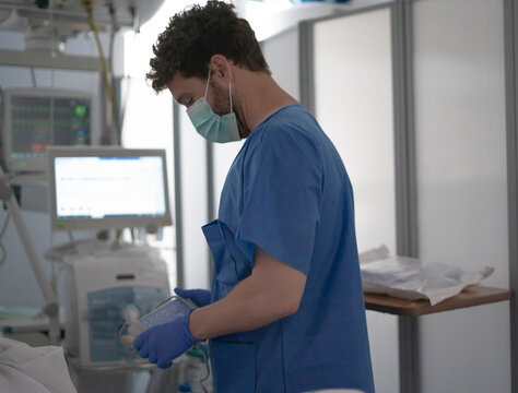 Medical professional wearing mask working in hospital intensive care