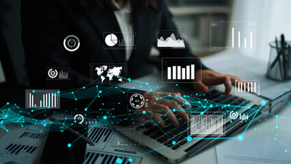 A business professional is focused on analyzing data trends using advanced technology and graphs displayed on a laptop in a modern office setting. Xenic
