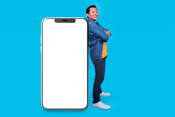 Full Length Of Asian Man Lean On Smart Phone Big Screen For Mock Up Isolated On Blue Background