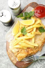 British Traditional Fish and chips served with sauce on gray textured table, flat lay