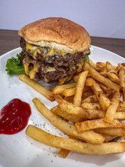 A mouth-watering double cheeseburger with melted cheese and fresh lettuce, served alongside perfectly golden, seasoned french fries and a dollop of vibrant ketchup on a white plate. A classic,