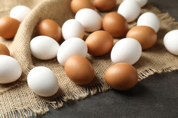 Many raw chicken eggs on grey table, closeup