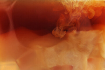 Tasty coffee with ice and milk as background, closeup