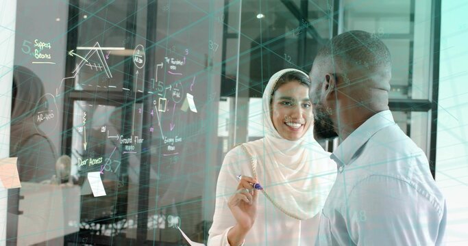 Writing headscarf-clad Indian professional drawing diagram on glass board in office, with marker - Powered by Adobe
