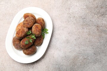 Tasty meat patties with parsley on grey table, top view. Space for text
