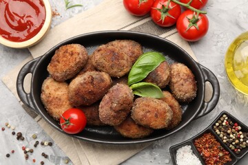 Tasty meat patties served on grey textured table, flat lay