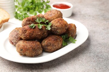 Tasty meat patties served on grey table, closeup