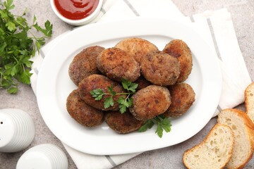 Tasty meat patties served on grey table, flat lay