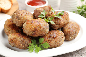 Tasty meat patties served on grey table, closeup